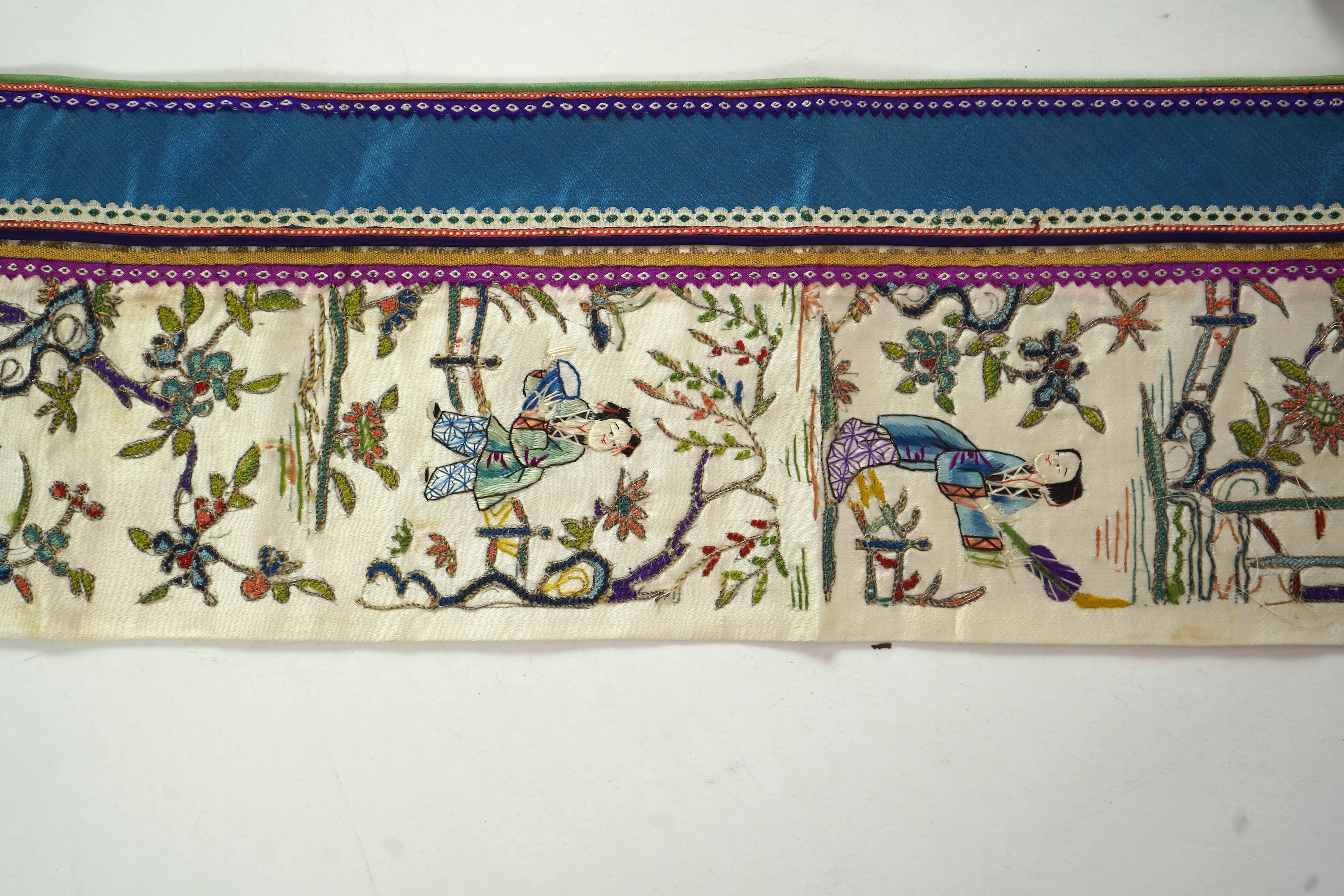 A Chinese embroidered silk panel of uncut robe borders, eleven similar sleeve panels and two other items, late Qing dynasty